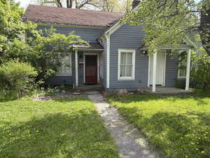 View of front of home featuring a chimney and a front lawn