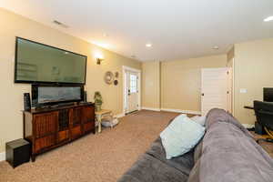Living area with carpet floors, baseboards, and recessed lighting
