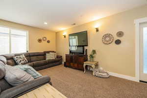 Living area with carpet floors, plenty of natural light, baseboards, and recessed lighting