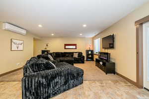 ADU Living room featuring a wall unit AC, light carpet, recessed lighting, and baseboards