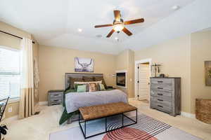 Primary Bedroom featuring light colored carpet, a ceiling fan, baseboards, recessed lighting, dual sided fireplace