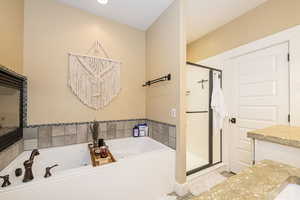 Primary Full bath with a stall shower, a jetted tub, and vanity