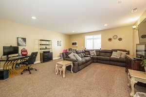 Living area with light carpet, a desk, recessed lighting, and baseboards