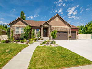 Craftsman inspired home featuring stone siding, a garage, and concrete driveway