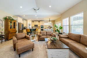 Living room featuring vaulted ceiling, recessed lighting, and light colored carpet