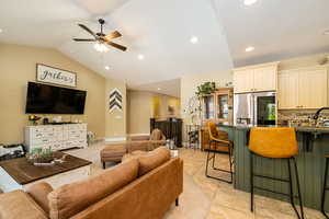 Living room with lofted ceiling, ceiling fan, and recessed lighting