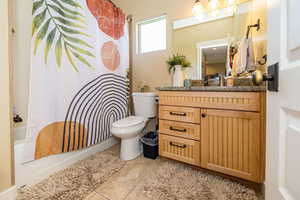Full bath with toilet, vanity, shower / tub combo with curtain, and tile patterned floors