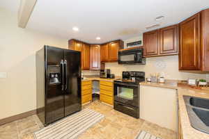 ADU Kitchen featuring black appliances, light countertops, a sink, recessed lighting, and baseboards