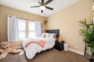 Bedroom with carpet flooring, baseboards, and ceiling fan