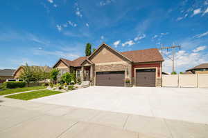 Craftsman inspired home with stone siding, an attached garage, and driveway, RV parking