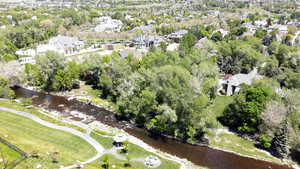 View of property location with nearby suburban area, a tree filled landscape, and a nearby body of water