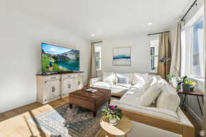 Living area with light wood finished floors, baseboards, and recessed lighting