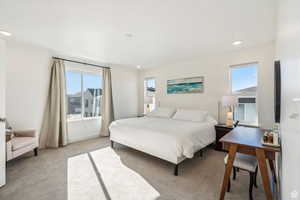 Bedroom with light colored carpet and recessed lighting