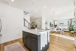 Kitchen with open floor plan, light wood-style flooring, light countertops, a center island, and recessed lighting