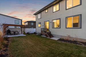 Back of house featuring a patio, a pergola, and stucco siding