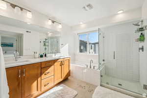 Bathroom with a garden tub, a stall shower, double vanity, and tile patterned floors