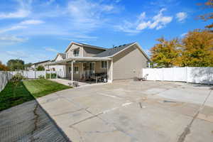 Back of house with a patio, driveway, and a gate