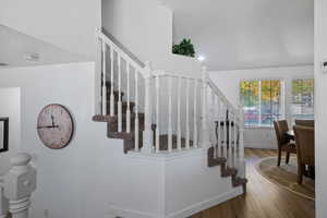 Stairway with wood finished floors and baseboards