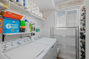 Clothes washing area featuring washer and dryer