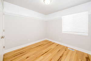 Unfurnished room with baseboards and hardwood / wood-style flooring