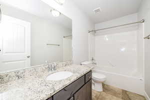 Full bath with toilet,  shower combination, and vanity