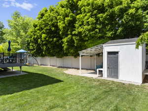 View of backyard deck, shed, and covered patio area