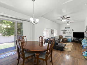 Spacious dining area in foreground and view of great room with two light/ceiling fan fixtures