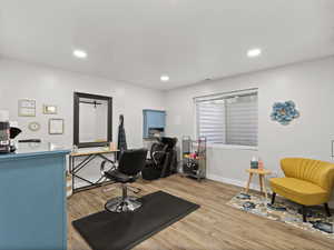 Newly finished basement bedroom (currently used as a salon) with LVP flooring and bright LED recessed lighting