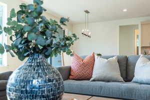 Living room featuring recessed lighting, healthy amount of natural light, and a chandelier