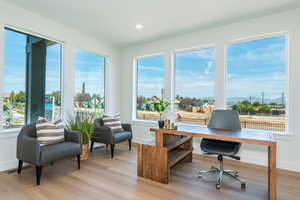 Home office featuring healthy amount of natural light, light wood finished floors, and recessed lighting