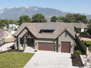 Modern farmhouse style home featuring board and batten siding, concrete driveway, a mountain view, an attached garage, and roof with shingles