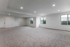 Spare room featuring recessed lighting, light colored carpet, and baseboards