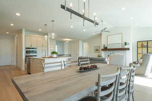Dining space featuring light wood-type flooring, recessed lighting, lofted ceiling, and ceiling fan