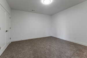 Carpeted spare room with baseboards