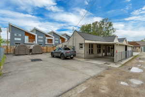 View of front of property featuring a storage shed, fence, an outbuilding, and a residential view