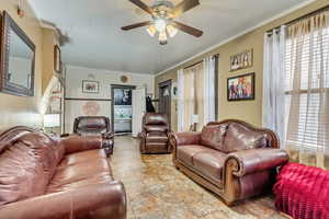Living area featuring ceiling fan and ornamental molding