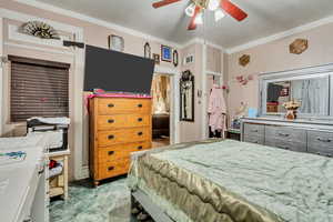 Bedroom featuring crown molding and a ceiling fan