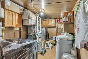 Basement featuring light floors, wooden ceiling, and washing machine and dryer