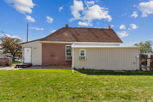 Rear view of property with brick siding, a chimney, and roof with shingles