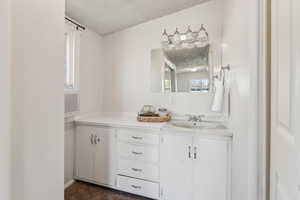 Bathroom featuring vanity, a textured ceiling, and healthy amount of natural light