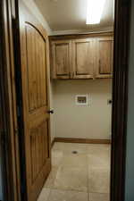 The dedicated laundry room has easy to clean tile flooring and cabinets that provide extra storage options.