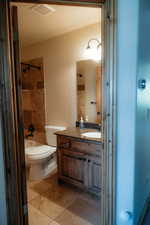 This hallway bathroom boasts lovely tile and antique bronze fixtures.