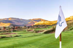 View of community with a mountain view, golf course view, and a lawn