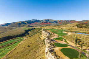 View of mountain backdrop with a golf course and a nearby body of water
