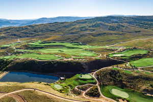 Aerial overview of property's location with a water and mountain view and a local golf course