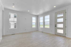 Entryway with light wood-style flooring, plenty of natural light, baseboards, a textured ceiling, and recessed lighting