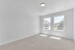 Carpeted spare room with baseboards and a textured ceiling