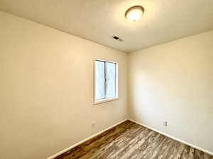 Unfurnished room with dark wood-style floors and baseboards