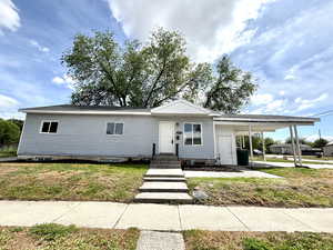 View of front of house with an attached carport and a front yard