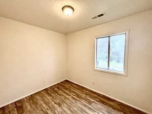 Unfurnished room featuring baseboards and wood finished floors